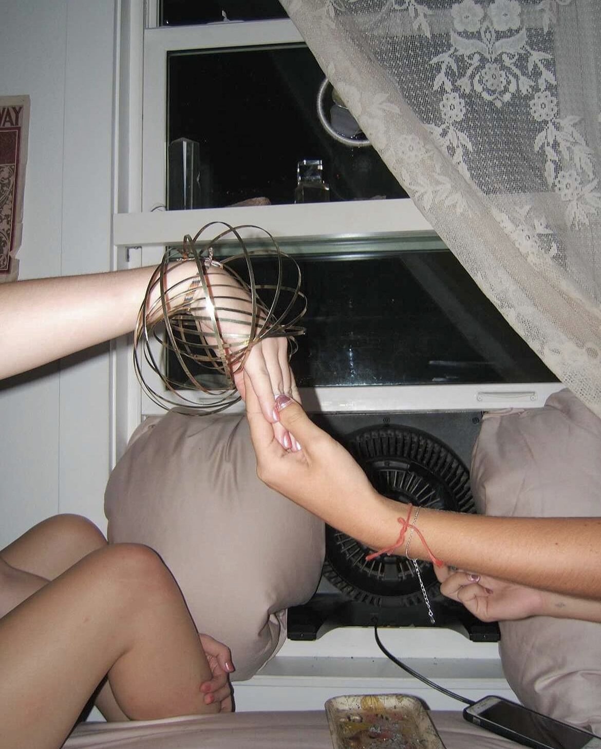 Friends sharing a playful moment with a gold flow ring at an intimate gathering